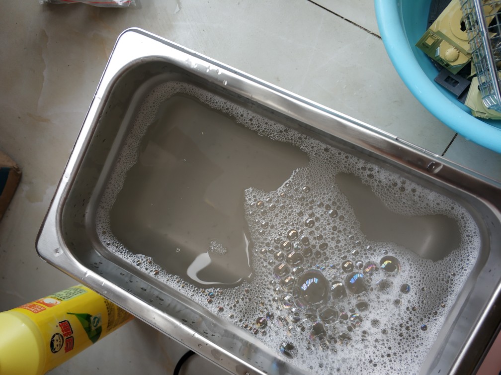 Image of an ultrasonic cleaner using dish soap as the cleaning agent.